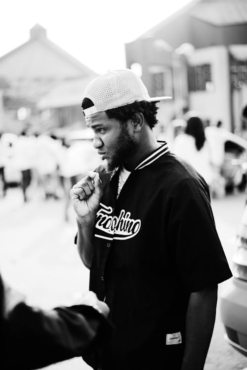 Grayscale Photo of Man Wearing a Cap 