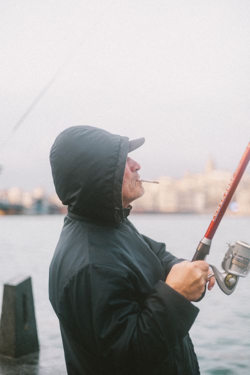 A Man Smoking a Cigarette while Fishing · Free Stock Photo