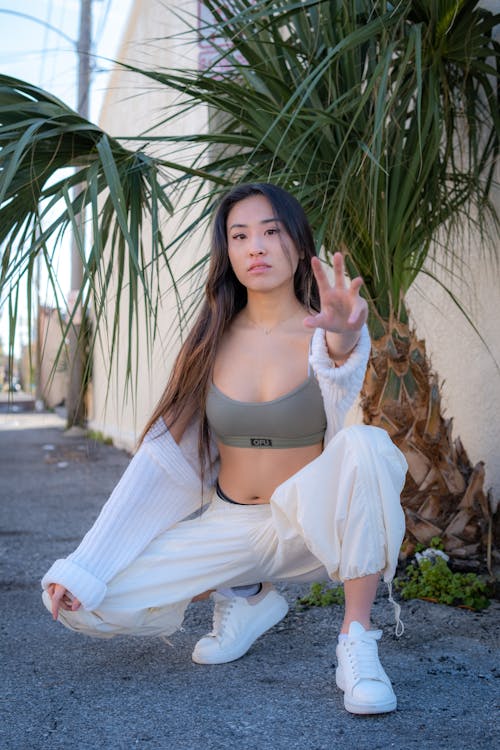 Young Woman in a Sports Bra and White Pants 