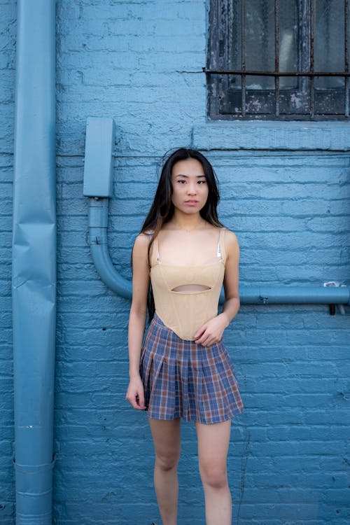 Woman in Beige Top and Plaid Skirt 