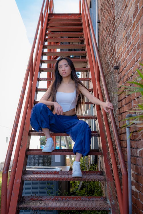 Woman Sitting on Metal Staircase