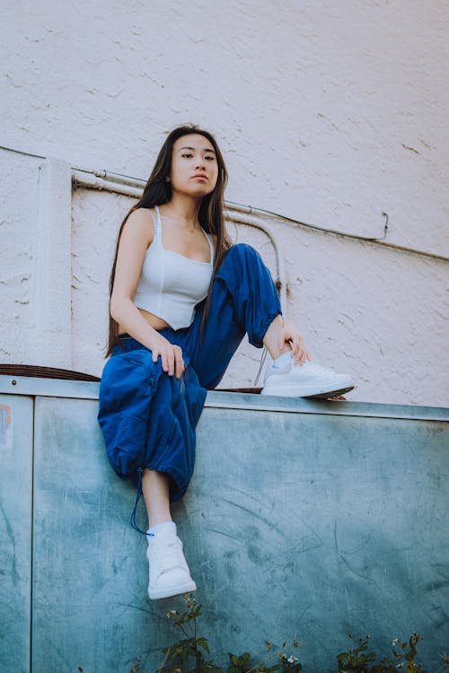 Woman in White Tank Top and Blue Pants Sitting