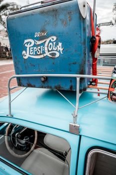 Close-up of a vintage car with a retro Pepsi-Cola cooler mounted on the roof.