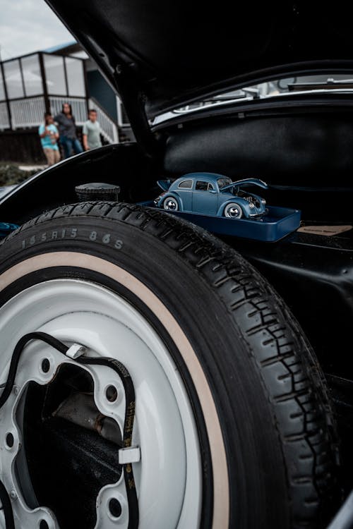 Blue Toy Car of Volkswagen Beetle Next to Spare wheel Under the Hood of a Real Type 1