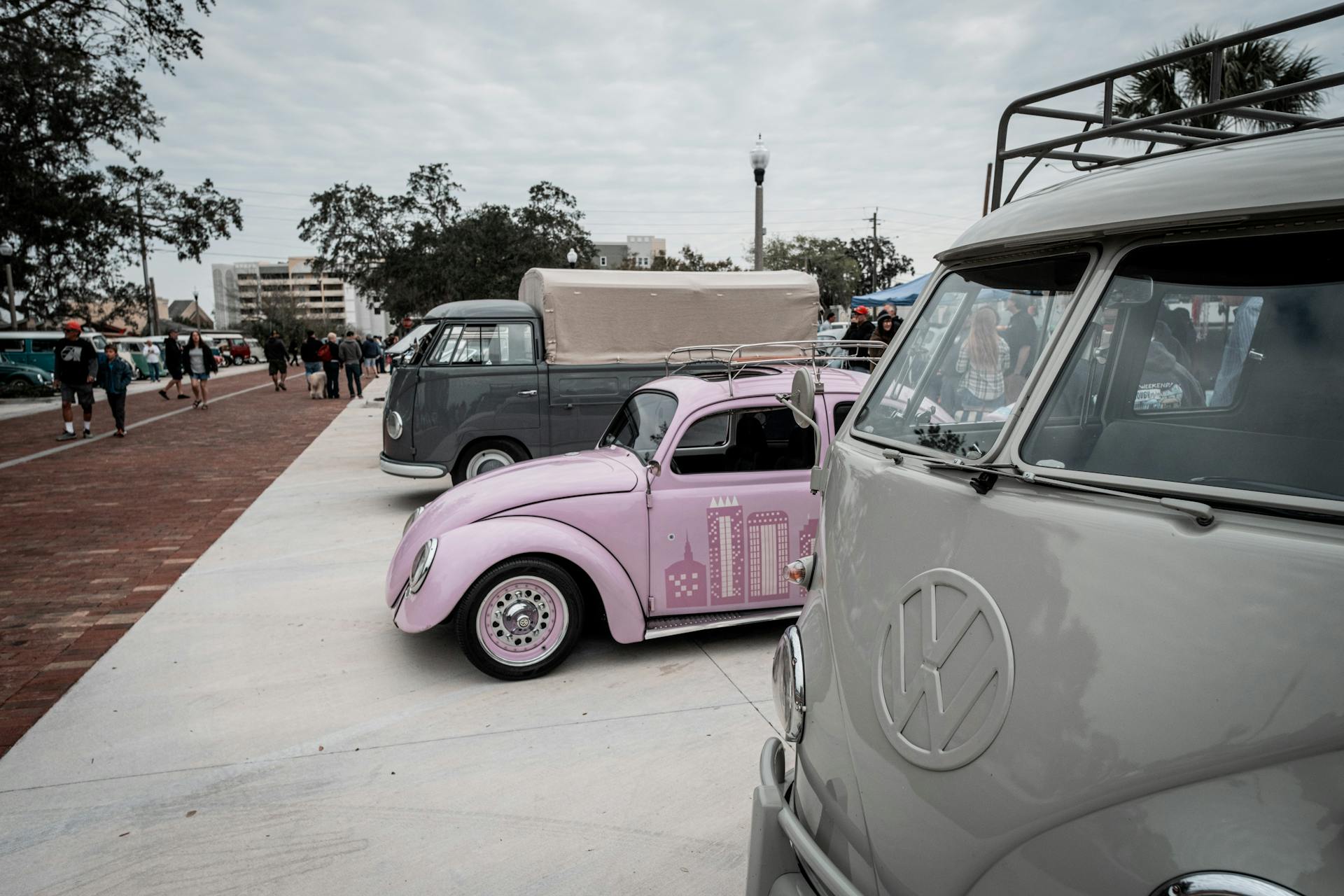 Pink Volkswagen Beetle Type 1 with Roof Rack and Sunroof Between Gray Type 2