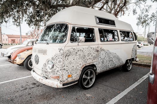 Classic vintage Volkswagen minibus decorated with intricate floral patterns in an outdoor setting.