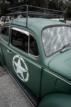 Close-up of a classic green Volkswagen Beetle featuring a prominent star emblem on the door.