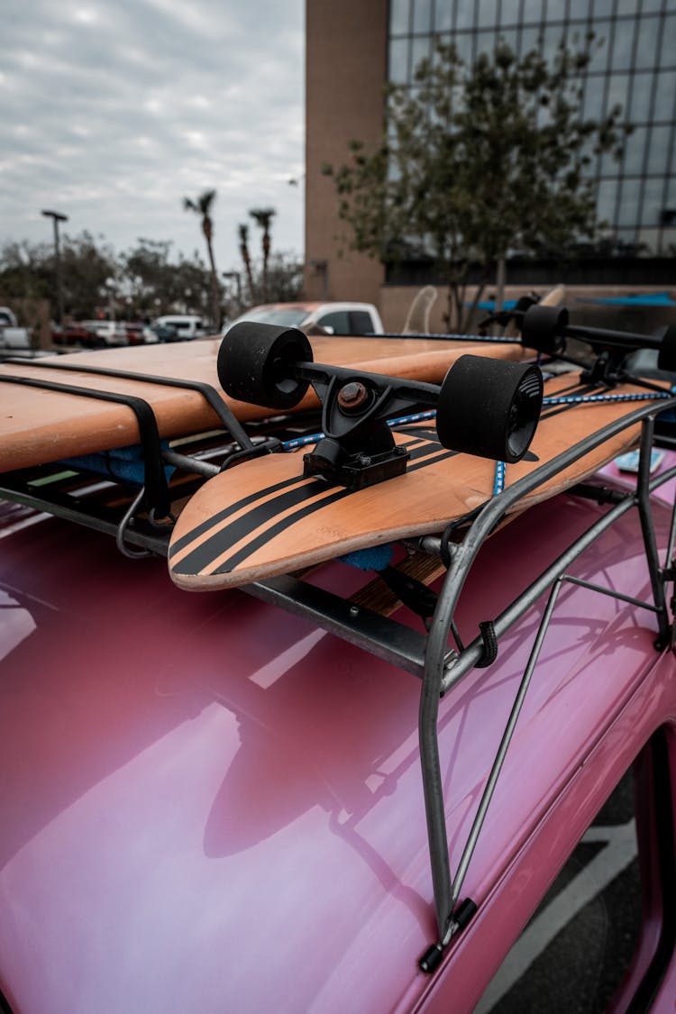 Longboard And Surfboard On The Roof Rack Of A Pink Volkswagen Beetle