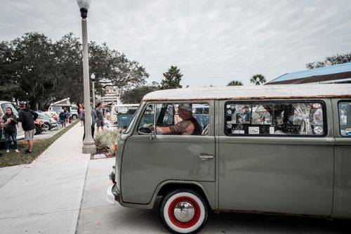 Free Classic Volkswagen van parked outdoors at an urban car show, showcasing its retro style. Stock Photo