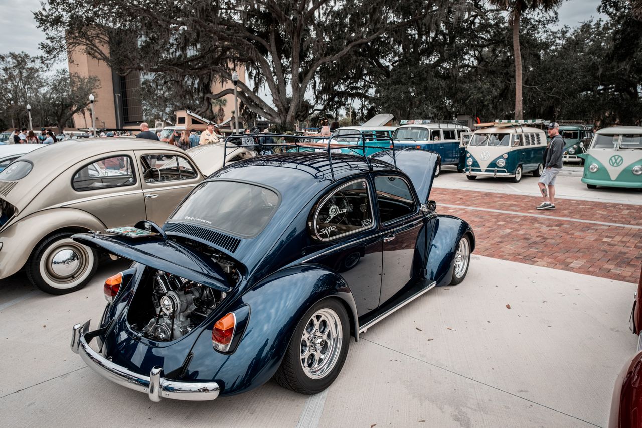 a vintage volkswagen beetle with an open trunk showcased at a classic