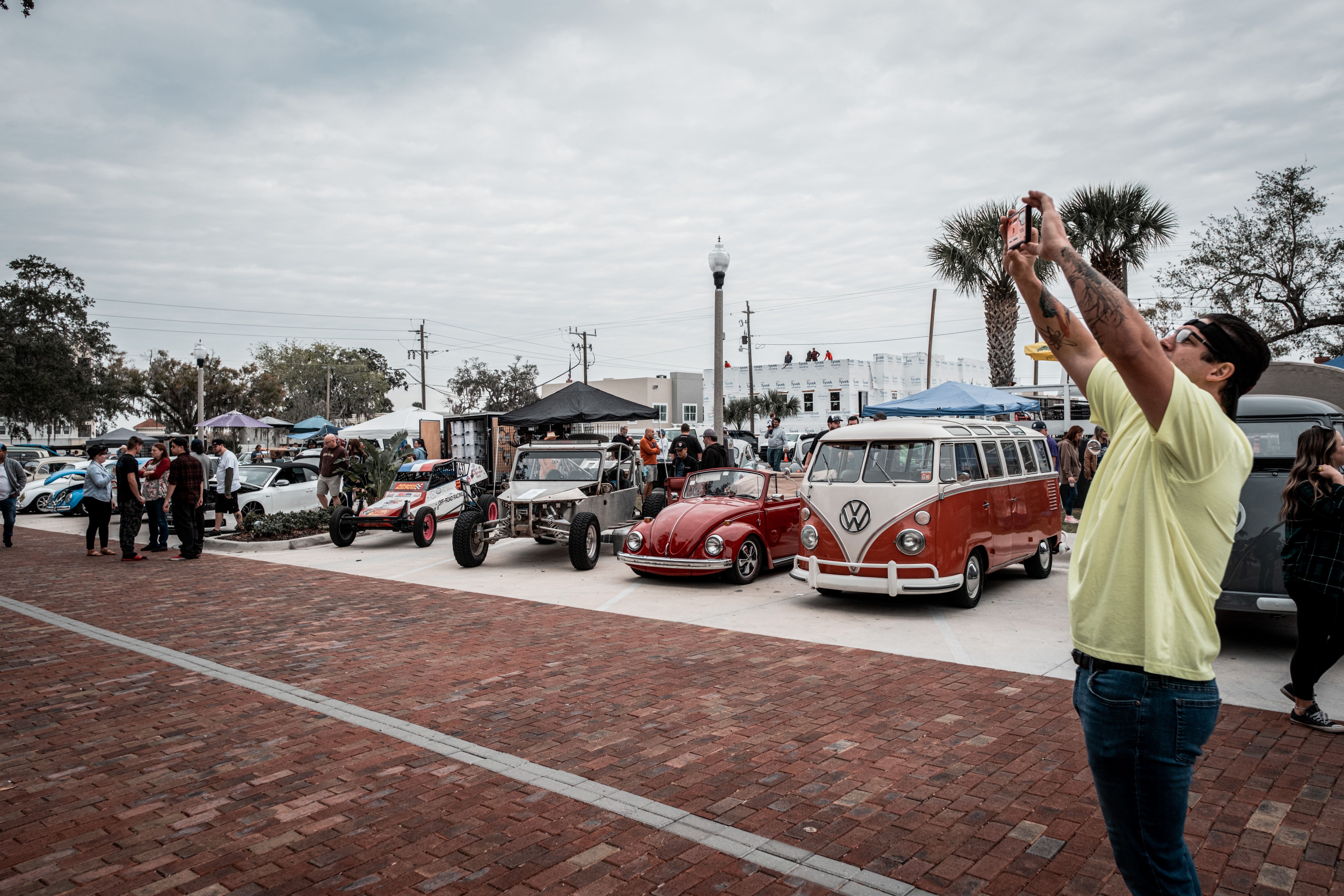 A lively outdoor vintage car show capturing classic Volkswagen vehicles and attendees.