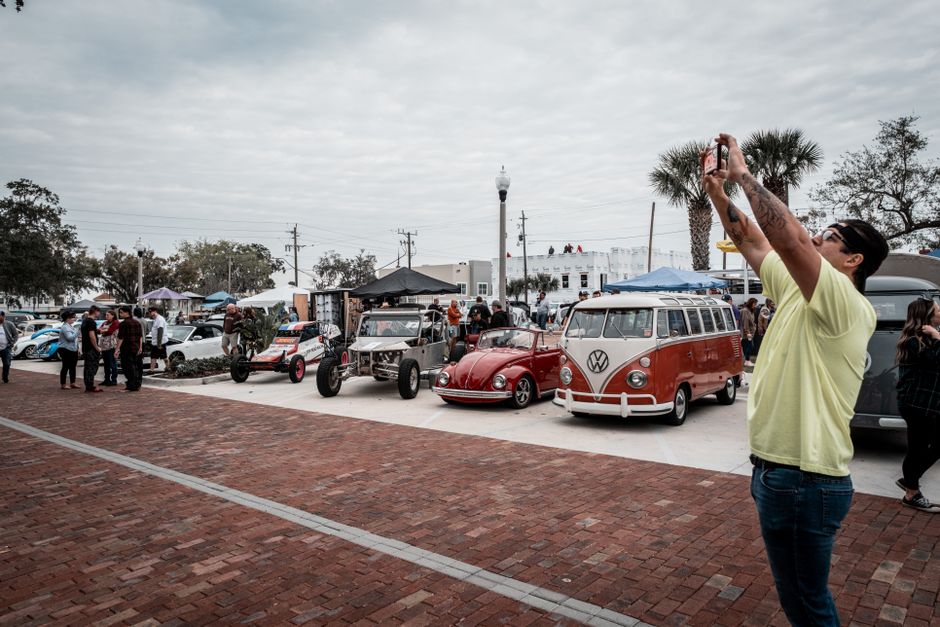 A lively outdoor vintage car show capturing classic Volkswagen vehicles and attendees.