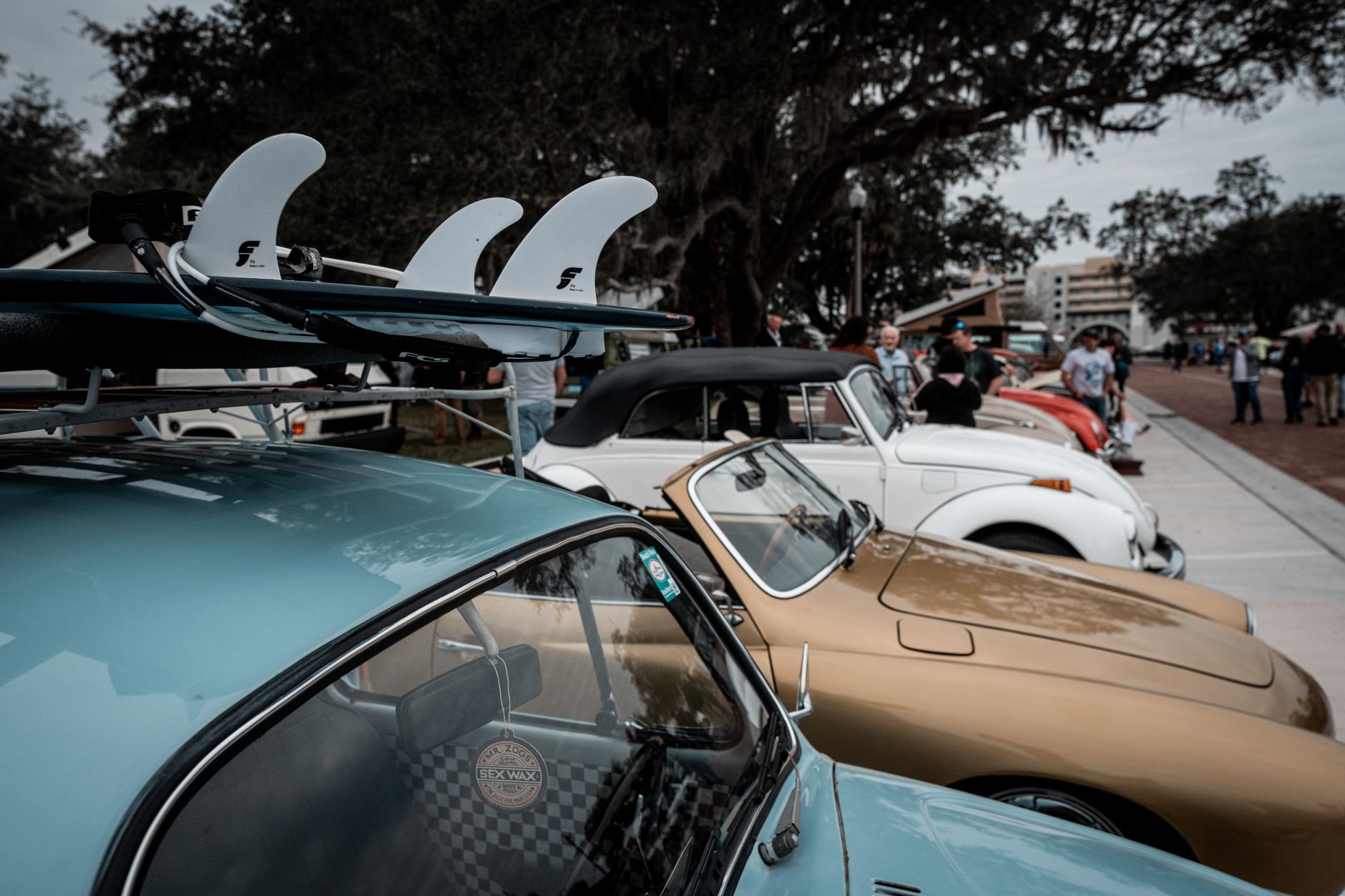 A lineup of classic Volkswagen cars at an outdoor vintage car event. Perfect for enthusiasts.