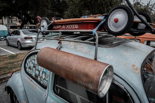 Free A nostalgic scene featuring a vintage Volkswagen Beetle with a retro Radio Flyer wagon on top. Stock Photo
