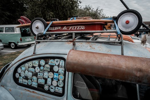 A rusted vintage Volkswagen car adorned with travel stickers and surfboards, showcasing nostalgic charm.