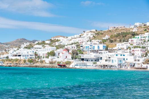 Beautiful view of Mykonos' iconic whitewashed buildings along the vibrant turquoise coast.