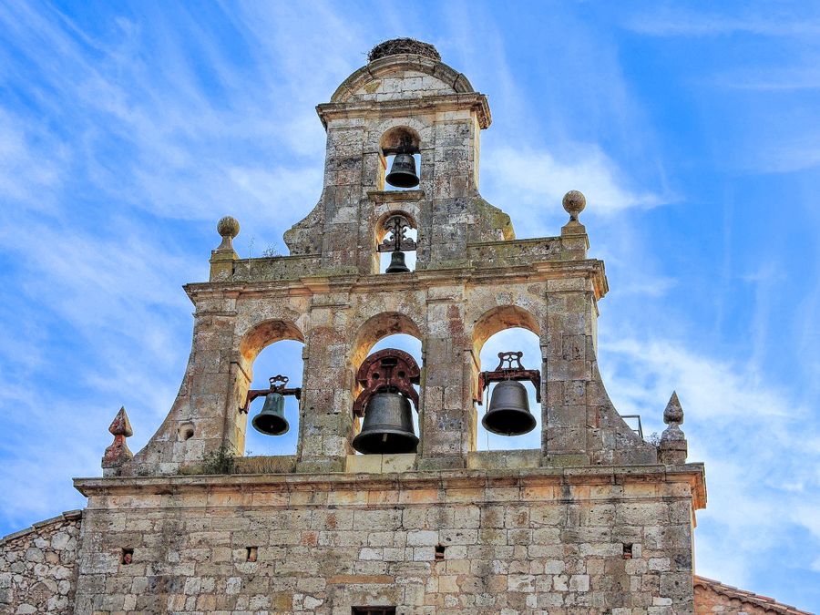 Stone bell gable holding four bells against an open sky — photo by Emilio Sanchez Hernandez on Pexels