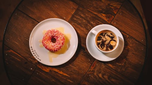 A Donut and Iced Coffee on a Wooden Table