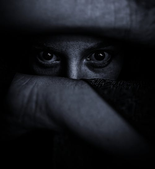 Free Spooky Eyes of a Person Looking Through Fingers Straight at the Camera Stock Photo