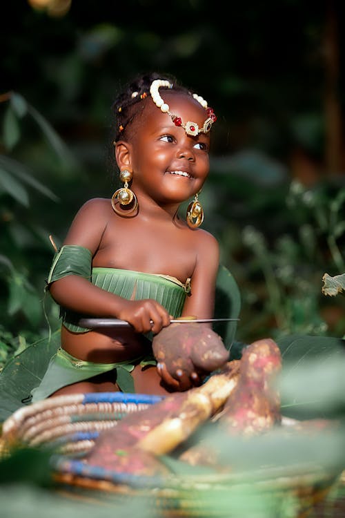 Smiling Child in Leaf Costume with Vegetable in Forest