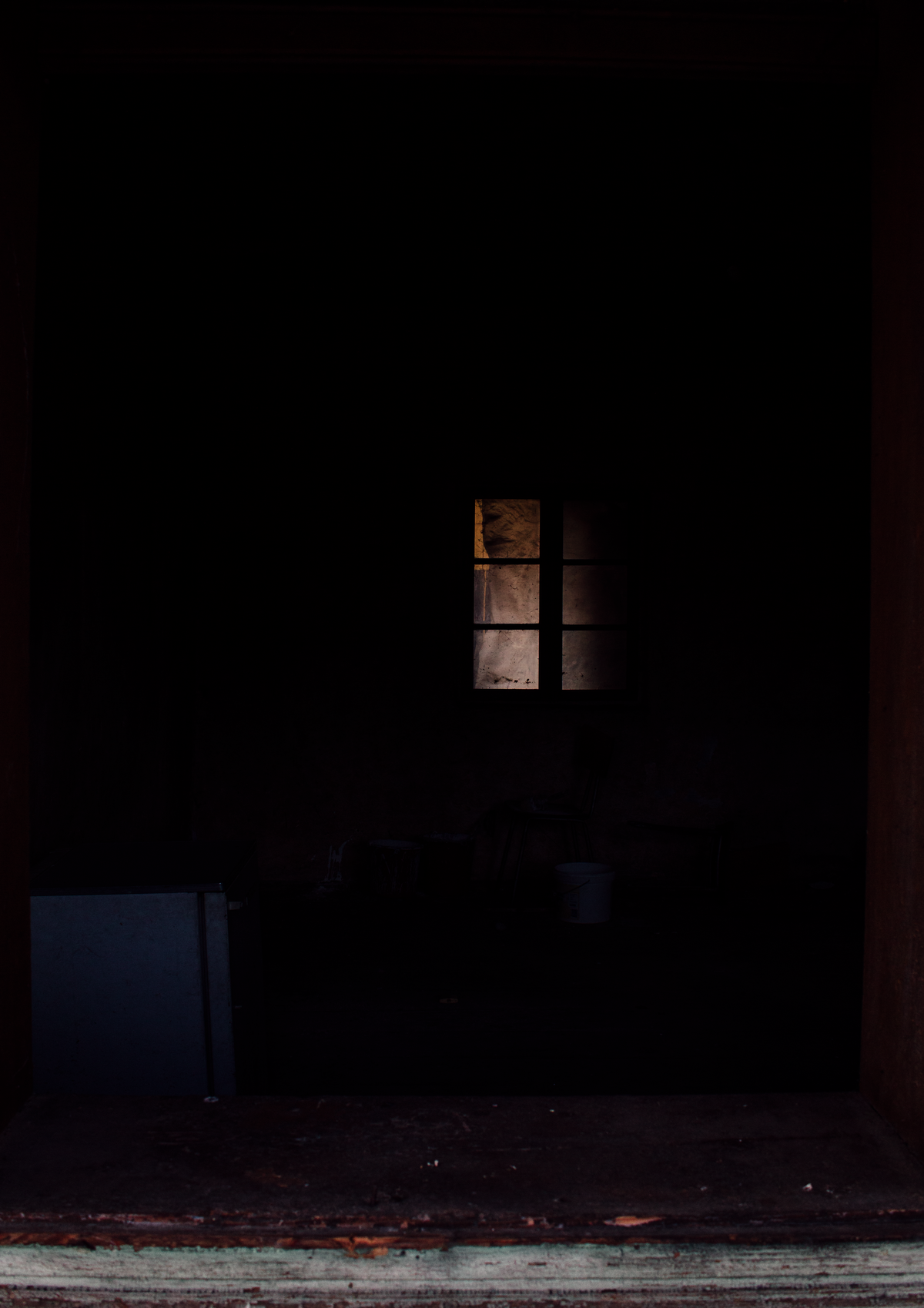Dark room lit by a single window
