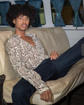 Portrait of a young man lounging in a retro van, showcasing vintage fashion and a relaxed vibe.