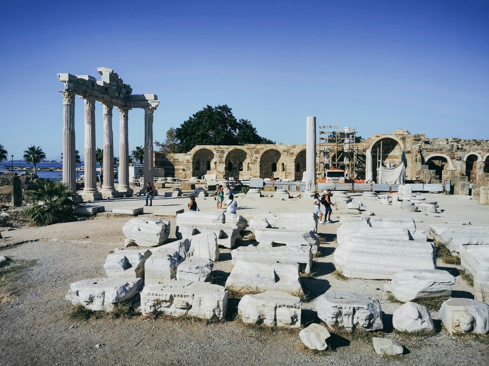 Scenic view of ancient Apollo temple ruins with visitors in Turkey.