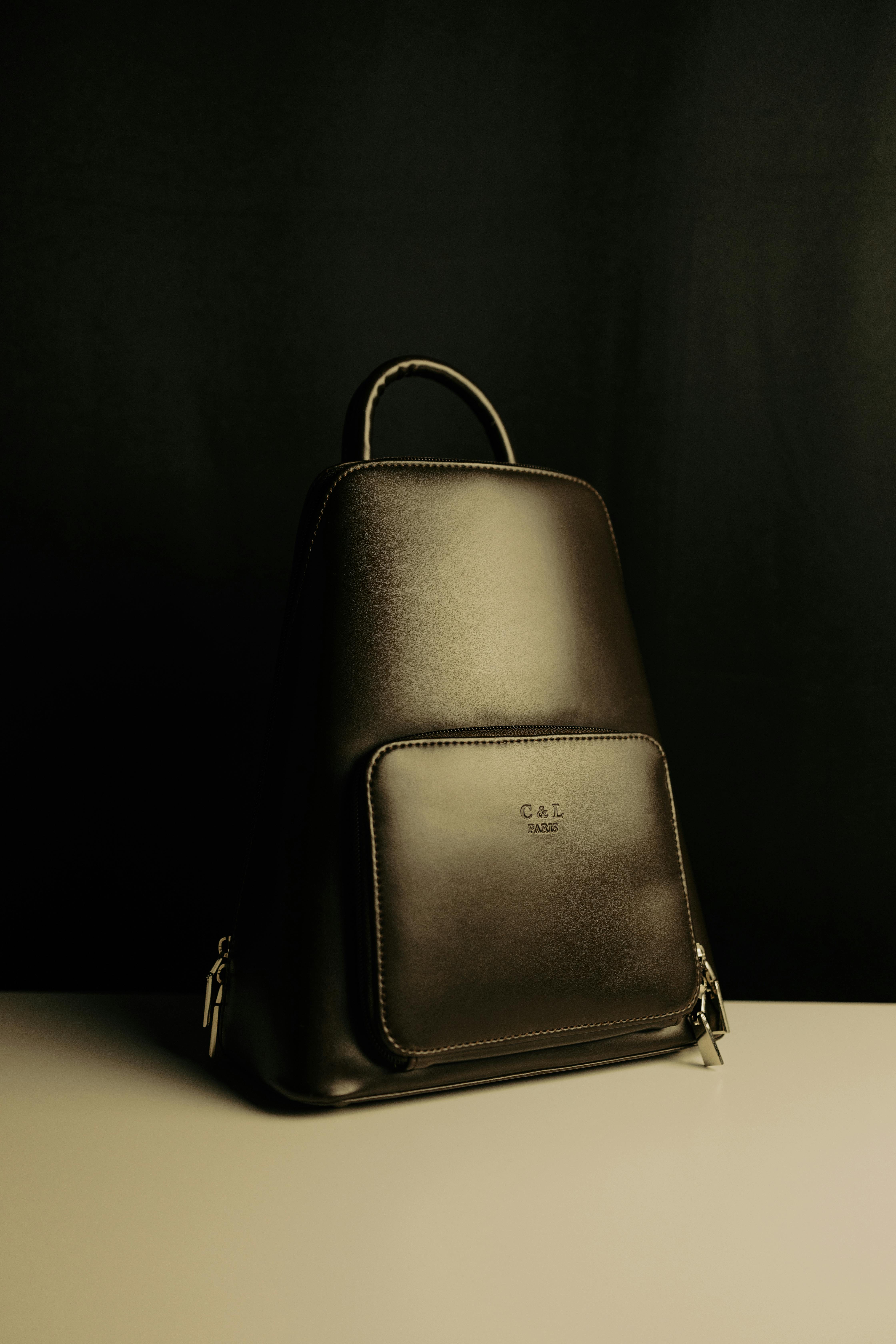 a black leather backpack on the white table