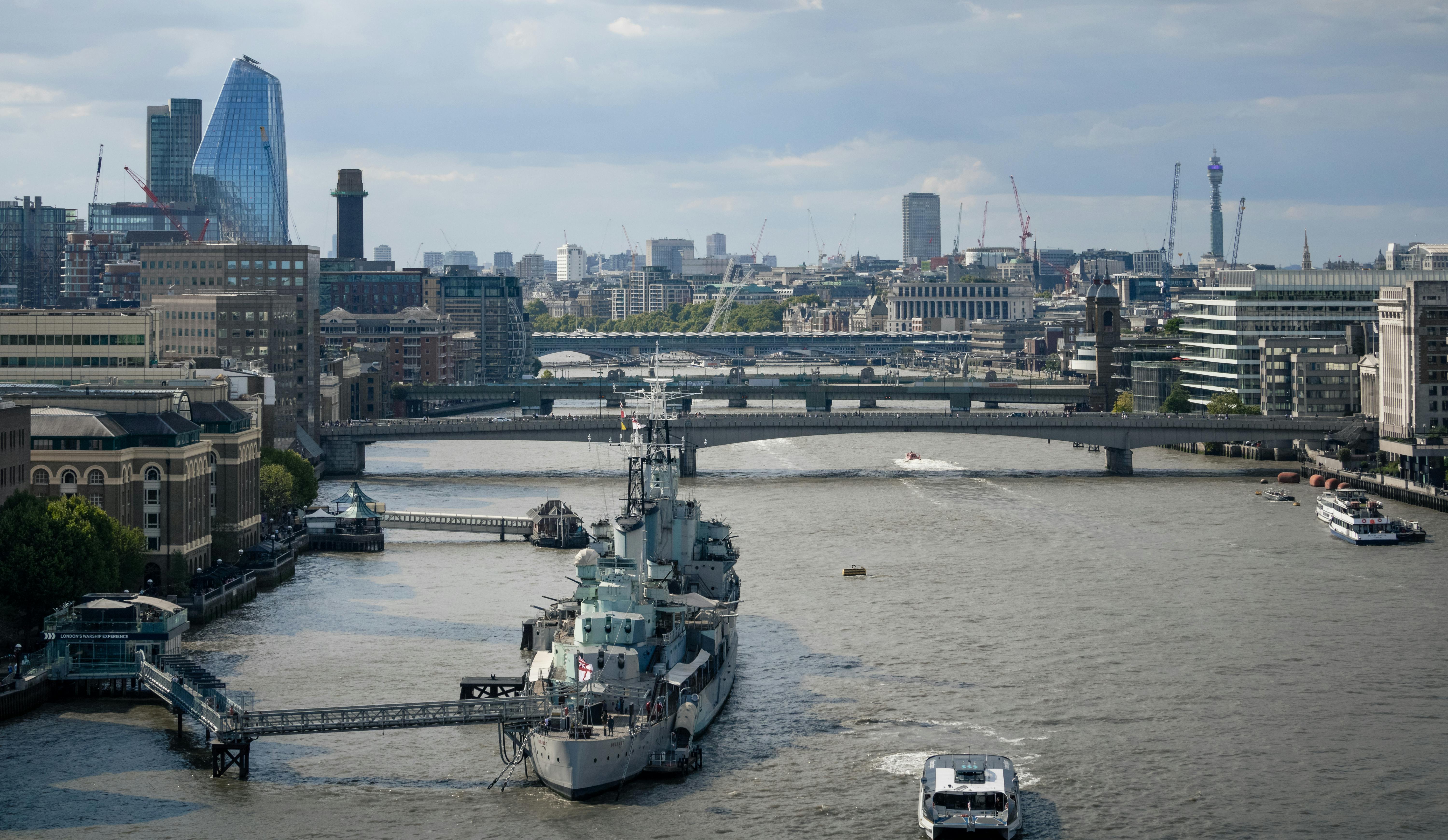 a boat is sailing in the river with buildings in the background