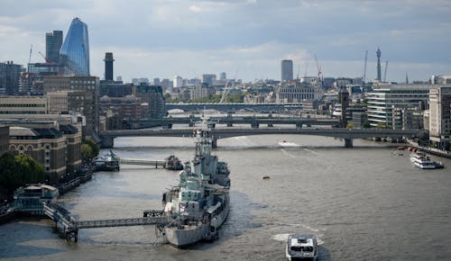 A boat is sailing in the river with buildings in the background