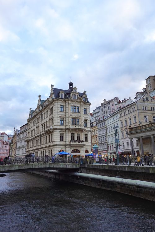Free View of historic buildings along the river in Karlovy Vary, Czechia, showcasing classic European architecture. Stock Photo