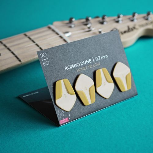 Free Close-up of honey yellow guitar picks displayed against a turquoise background. Stock Photo