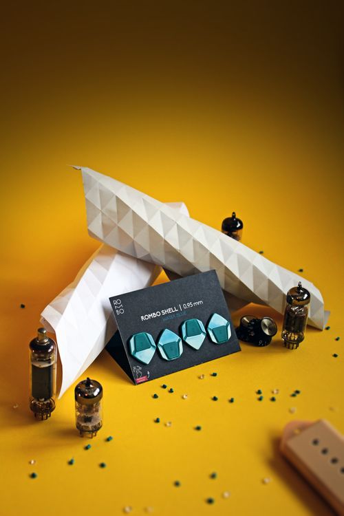 Free Stylish origami plane with guitar picks and retro tubes on a vibrant yellow background. Stock Photo
