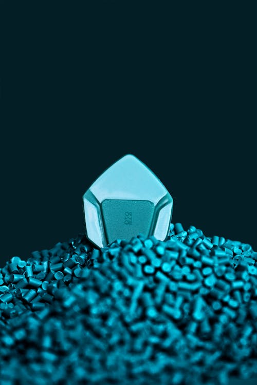 Close-up of a Blue Guitar Pick Lying on a Pile of Blue Beads