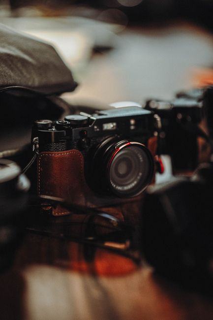 Close-up of a vintage camera with a leather case, emphasizing its classic design and selective focus.