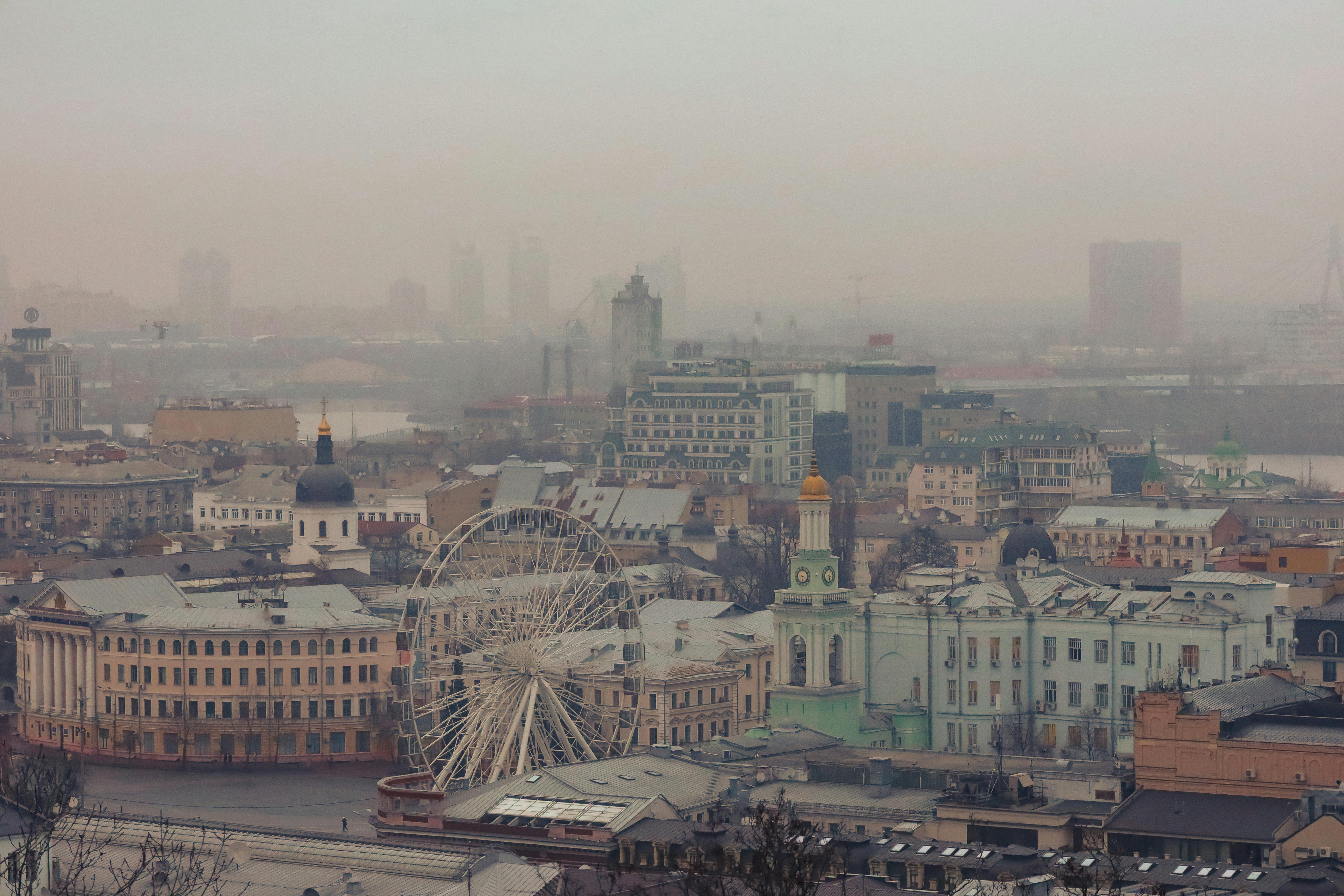 A foggy aerial view of Kiev, Ukraine, showcasing the urban landscape with a Ferris wheel.
