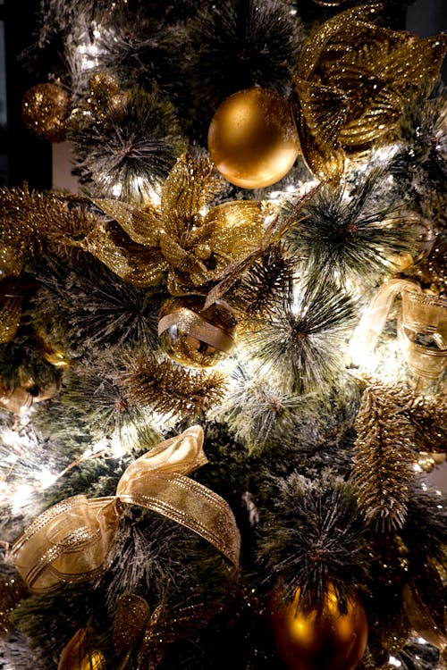 A close up of a christmas tree with gold and silver decorations