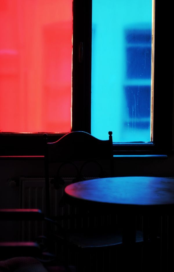 Cafe interior lit by red and cyan stained glass, photo by Berkay Zeyrek on Pexels
