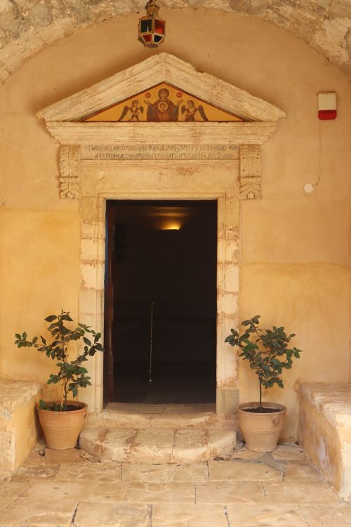 Free Beautiful stone entrance of Arkadi Monastery with potted plants, crest, and arch. Stock Photo