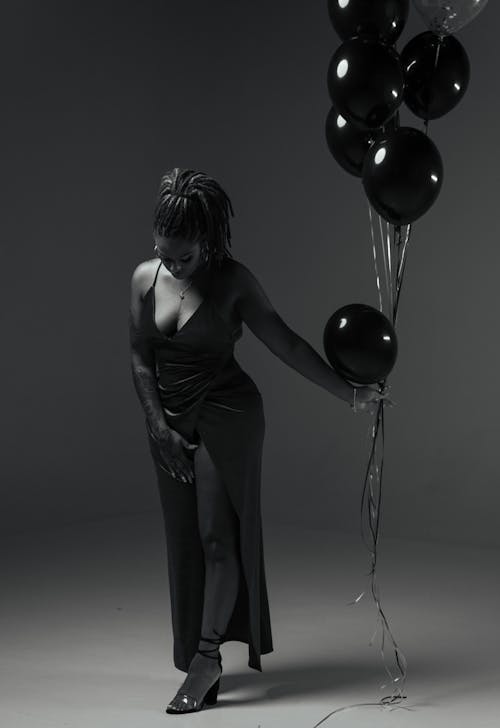 Free Grayscale Photo of Woman Looking Down While Holding Balloons Stock Photo