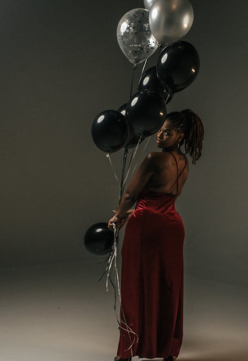 Woman Looking Back While Holding Balloons