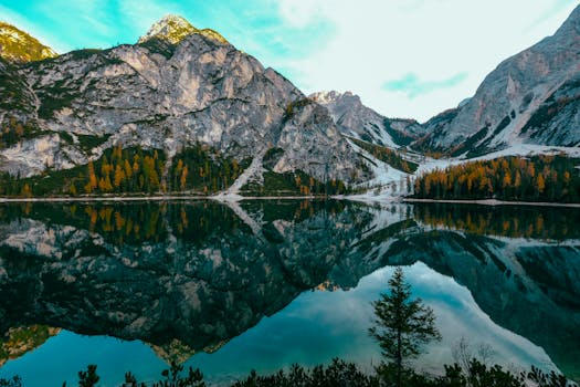 宁静的湖泊倒映着雄伟的山脉和秋叶，景色令人惊叹