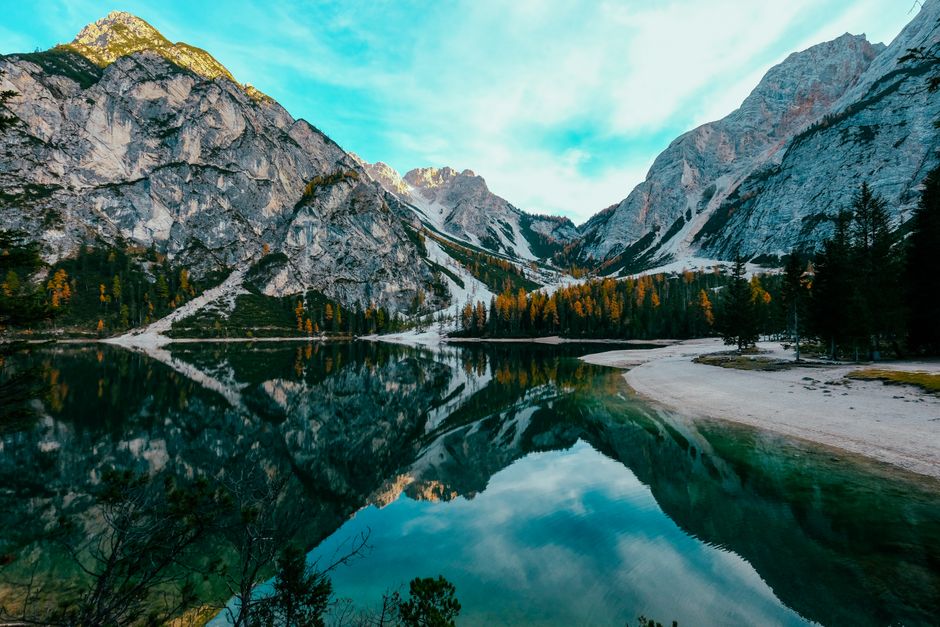 A breathtaking view of mountains and a reflective lake surrounded by trees.