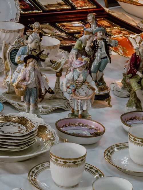 Free A collection of ornate antique figurines with elegant teacups and plates in a close-up vertical shot. Stock Photo