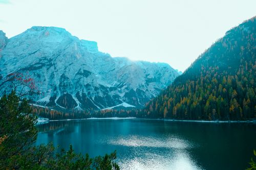 Free Breathtaking view of a mountain lake with autumn trees and snow-capped peaks reflecting on the water. Stock Photo
