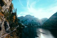 宁静的高山湖泊上，日出映照着高耸的山峦和生机勃勃的秋叶