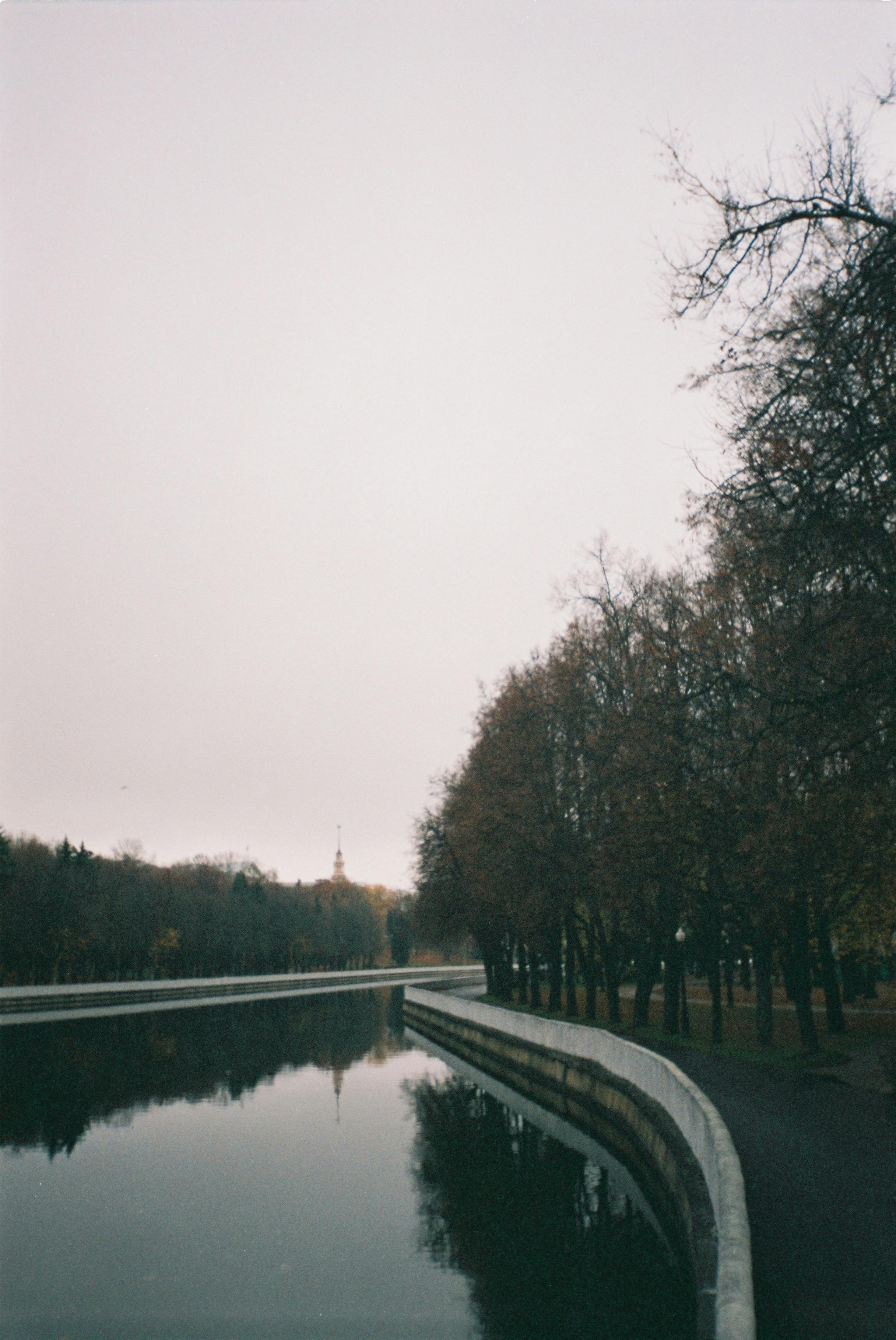 Peaceful riverside scene with reflections and autumn trees.