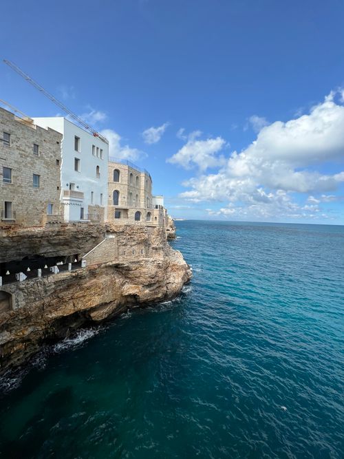 Free Stunning seaside architecture over cliffs with blue skies and clouds in Italy. Stock Photo
