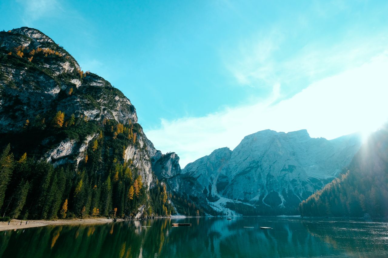 breathtaking view of mountains and a calm lake reflecting the bright s