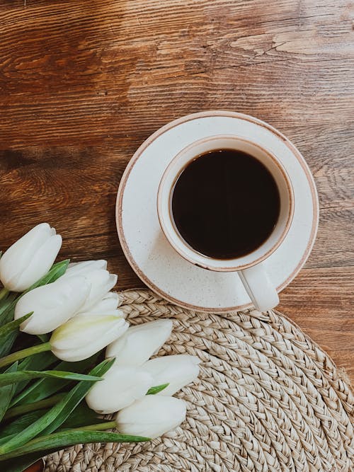 Free Black Coffee in Cup and Tulips on Wooden Table Stock Photo